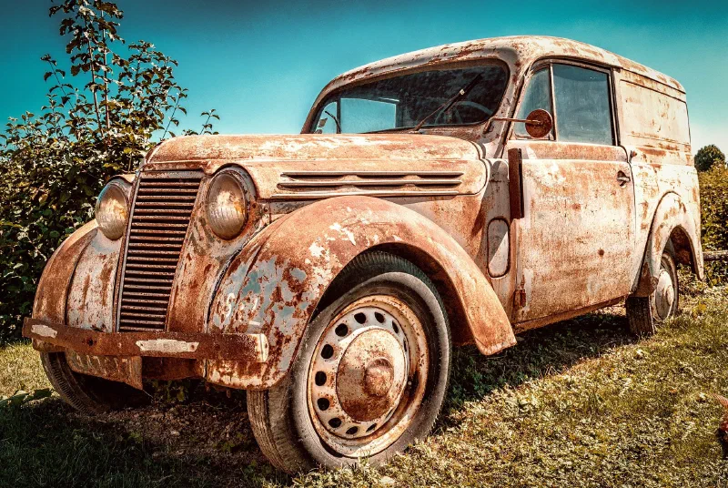 Old rusty van parked on grass