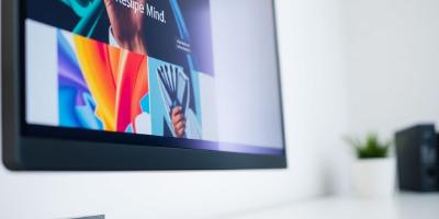 Sleek monitor displaying vibrant web design, code snippets.