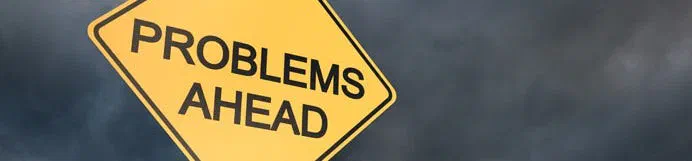 Yellow Problems Ahead road sign against dark clouds